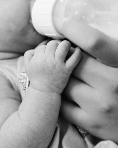 grayscale photo of baby feeding