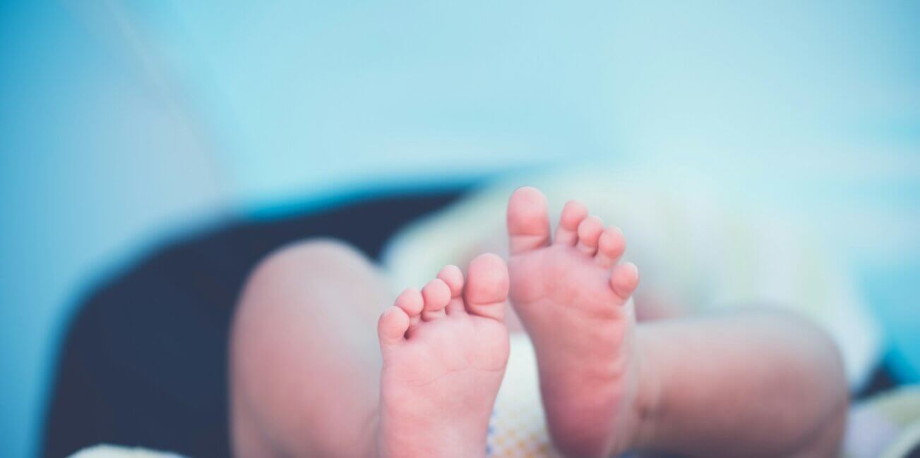 shallow focus photography of baby wearing white diaper lying