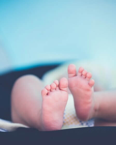 shallow focus photography of baby wearing white diaper lying