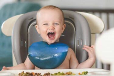 baby lying on white and blue bathtub