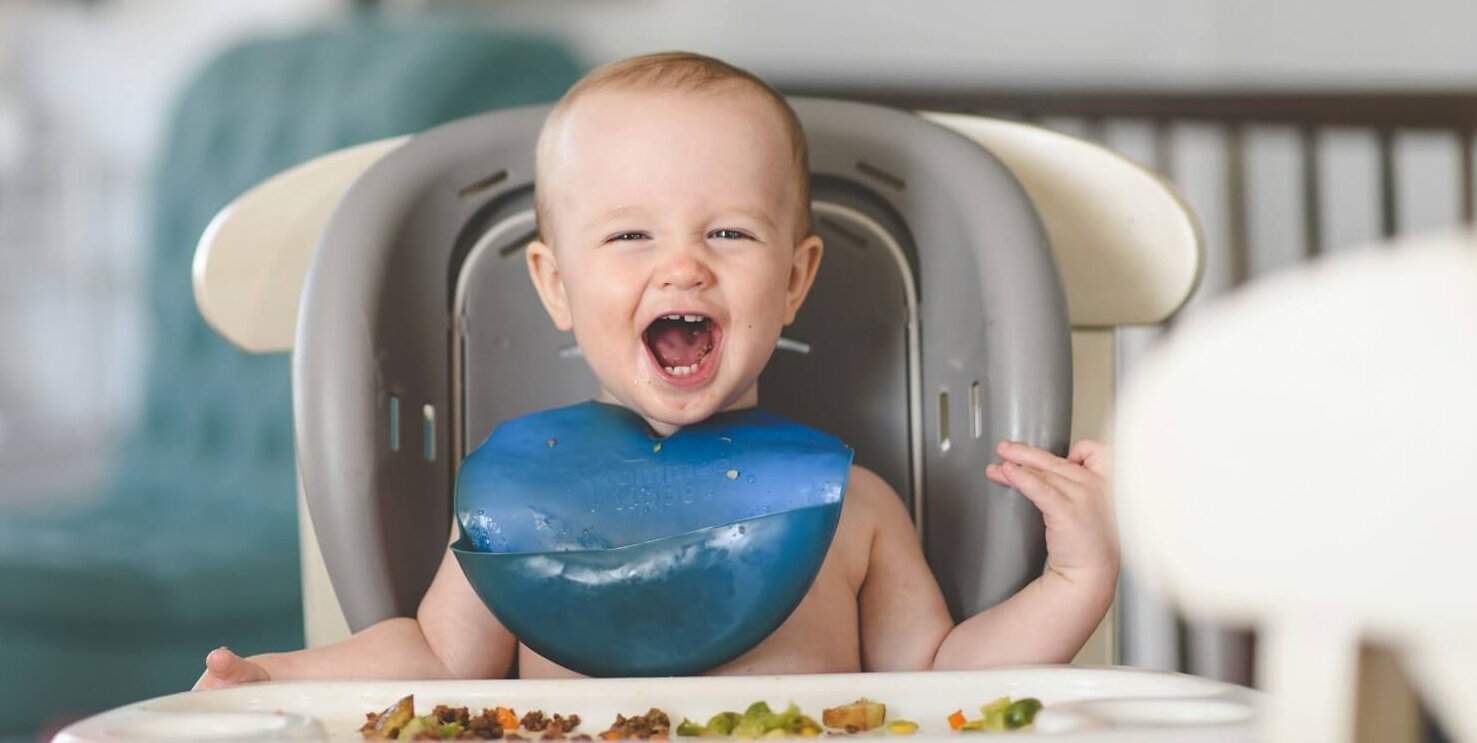 baby lying on white and blue bathtub